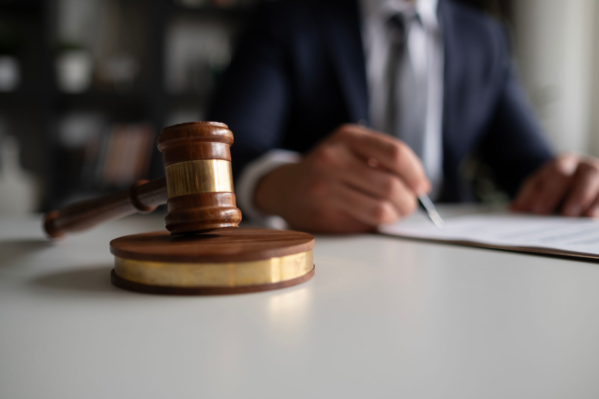 Judge gavel with attorney signing documents — Khemraj Law Firm PC